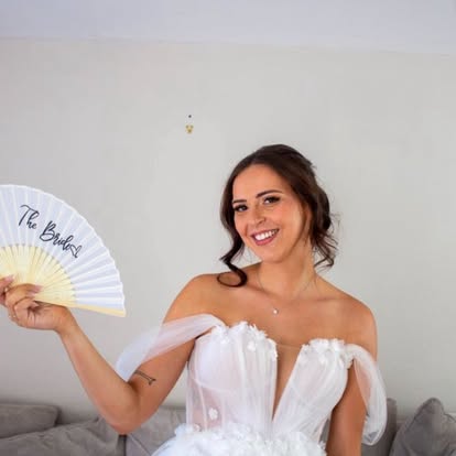 Bride holding a fan after bridal hair and makeup